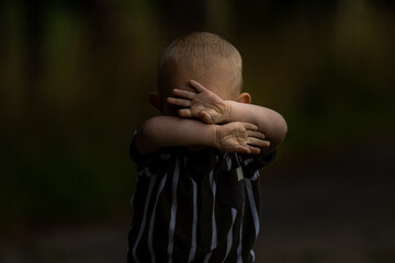 stop violence against children child covering his face with his hands  protecting himself 