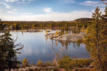 Photo of a lake near Yellowknife Canada on a beautiful, calm fall afternoon with reflections in the water
