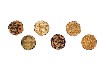 Banana cup cake with a variety of toppings,almond,pumpkin seeds,dark-white chocolate,currant,cashews isolated on white background with top view.