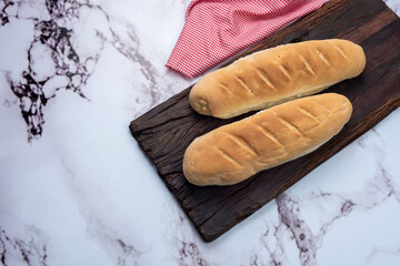Whole and sliced long homemade bread on natural and fresh wooden board