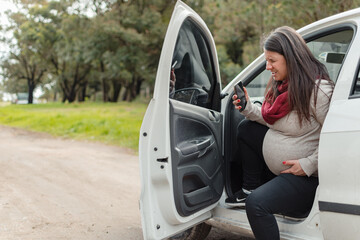 Pregnant Latina stops her car in the middle of a muddy road because of her strong contractions.