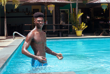 Dark skinned man enjoying the water in the pool