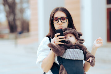 Upset Mother with Newborn in Baby Carrier Reading a Text Message