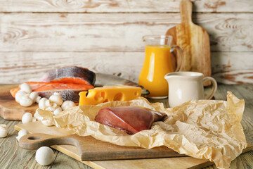 Different healthy products with vitamin D on wooden background