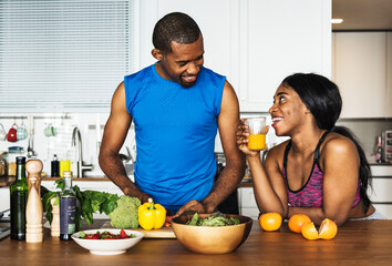 Black couple cooking healthy food in the kitchen