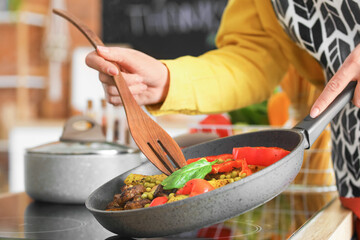 Young housewife cooking in kitchen at home
