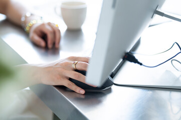 デスクトップコンピュータを使用する女性の手元