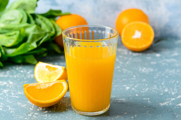 Glass with tasty orange juice on color background