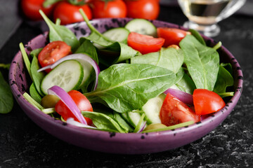 Plate with healthy fresh salad on dark background