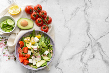 Plate with healthy salad with feta cheese on light background