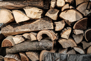 Natural wooden background - closeup of chopped firewood. Firewood stacked and prepared for winter Pile of wood logs