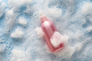 Bottle of cosmetic product with foam on color background