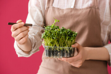 Woman with fresh micro green on red background, closeup