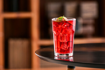 Glass of tasty ice tea with lime on table in room