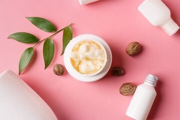 Jar of shea butter and cosmetic products on color background, closeup