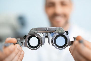 Male ophthalmologist with trial frames in clinic, closeup