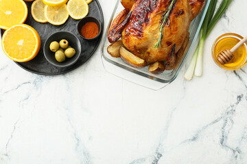 Baking dish with tasty chicken, orange, lemon, honey and vegetables on light background