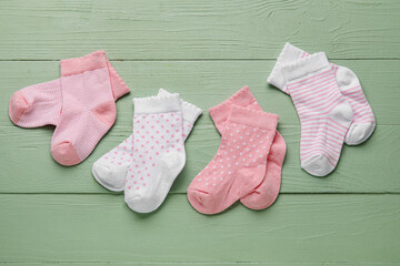 Different baby socks on color wooden background