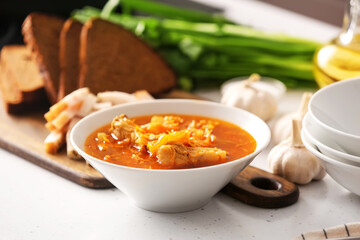 Bowl with delicious borscht on table in kitchen