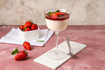 Glass with tasty strawberry panna cotta on table