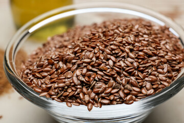 Bowl with flax seeds on table, closeup