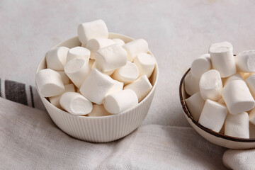 Bowls with tasty marshmallows on light background, closeup