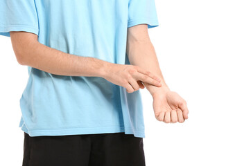 Sporty young man counting pulse on white background