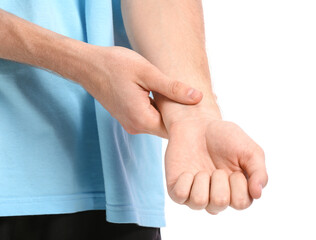 Sporty young man counting pulse on white background, closeup
