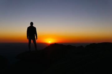 Fototapeta na wymiar Silhouette On Mountain Top Sunset