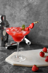 Glass of tasty strawberry margarita on grunge background