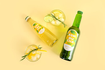 Composition with fresh kombucha tea in bottles and glasses on color background