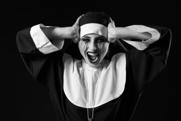 Woman dressed for Halloween as nun on dark background