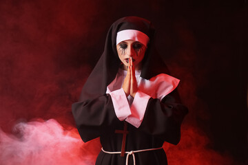 Woman dressed for Halloween as nun on dark background
