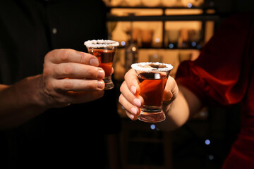 Friends with shots of tasty tequila in bar