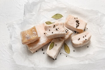 Parchment with pieces of salted lard on light background