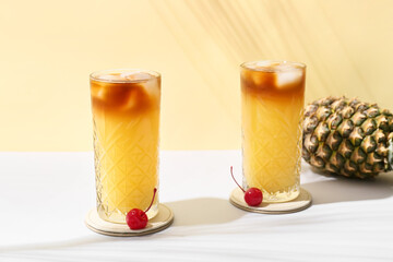 Glasses with delicious mai tai cocktail on white table against color background