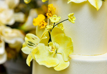 yellow orchid close-up on wedding cake, natural flowers