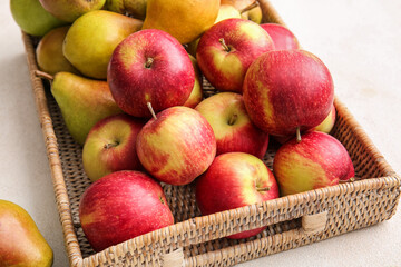 Tray with ripe pears and apples on light background, closeup