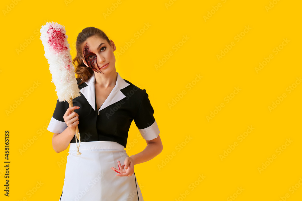 Wall mural woman dressed for halloween as chambermaid with dust brush on color background