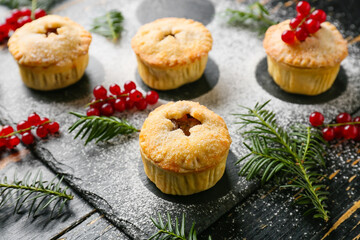 Tasty mince pies on dark wooden background
