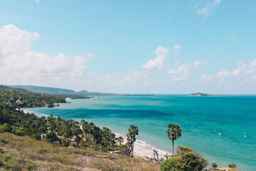 View of Rote Tropical Beach with deep turquoise blue ocean and small exotic island in the center in Rote Island, Indonesia.