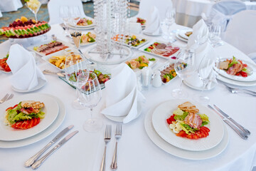 Beautifully decorated catering banquet table with different food snacks and appetizers , fresh fruits on corporate party event or wedding celebration
