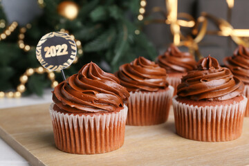 Tasty cupcakes for New Year 2022 celebration on table
