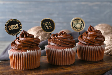Tasty cupcakes for New Year 2022 celebration on table