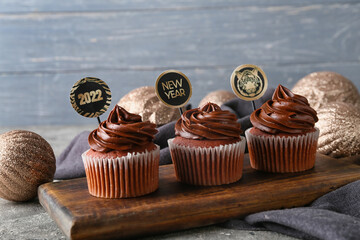 Tasty cupcakes for New Year 2022 celebration on table