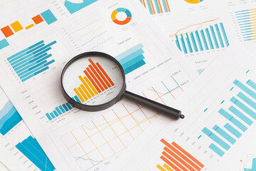 Business graphs, charts and magnifying glass on table. Financial development, Banking Account,...