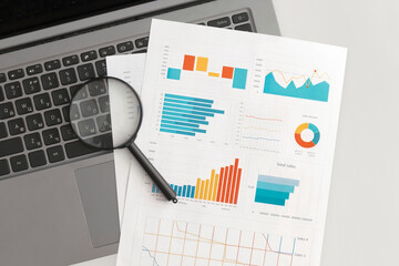 Business graphs, charts and magnifying glass on table. Financial development, Banking Account, Statistics
