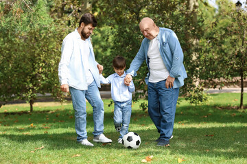 Obraz premium Man, his little son and father playing football in park