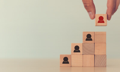 Human resource management (HRM), recruitment and leader business concept. Man's hand puts wooden...