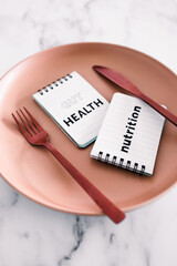 gut health nutrition text on notepads on top of dining plate with fork and knife, healthy nutrition and scientific research